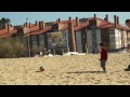 Max playing footy on the beach with mum