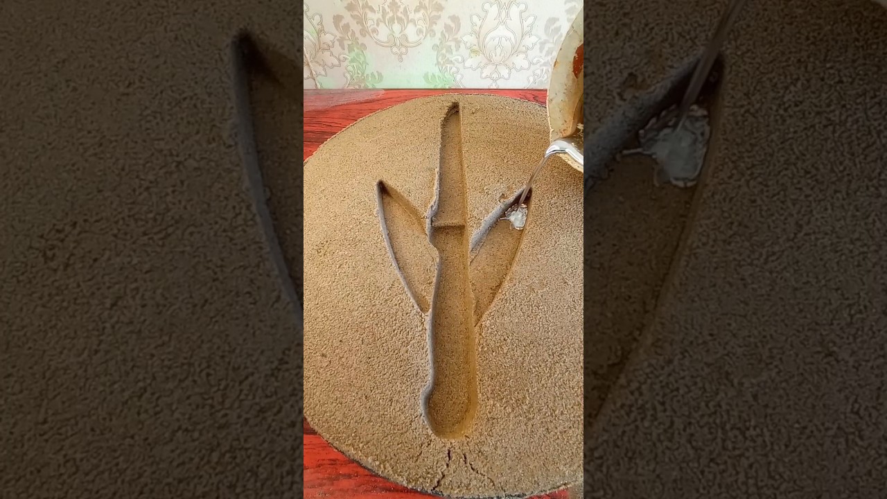 Double-sided metal melting knife on sand 