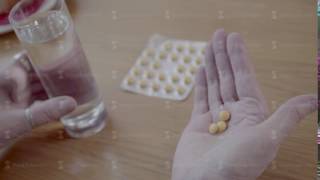 Close-up of round yellow pills in the palm of mature older person