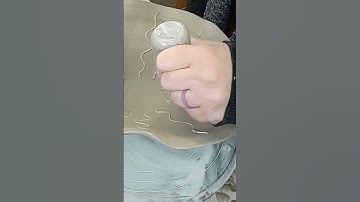 Carving and slip trailing a freeform pottery bowl