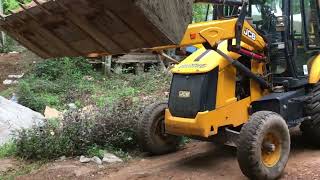 jcb 3dx digging and transporting soil for making road to enter new house