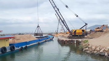 Cảnh sà lan tại bến tân cảng sài gòn. Xáng dây siêu to cạp cát, cạp đất lên xe container và xe ben