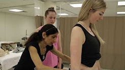 photo of instructor with femal student applying force to the back of a person lying down