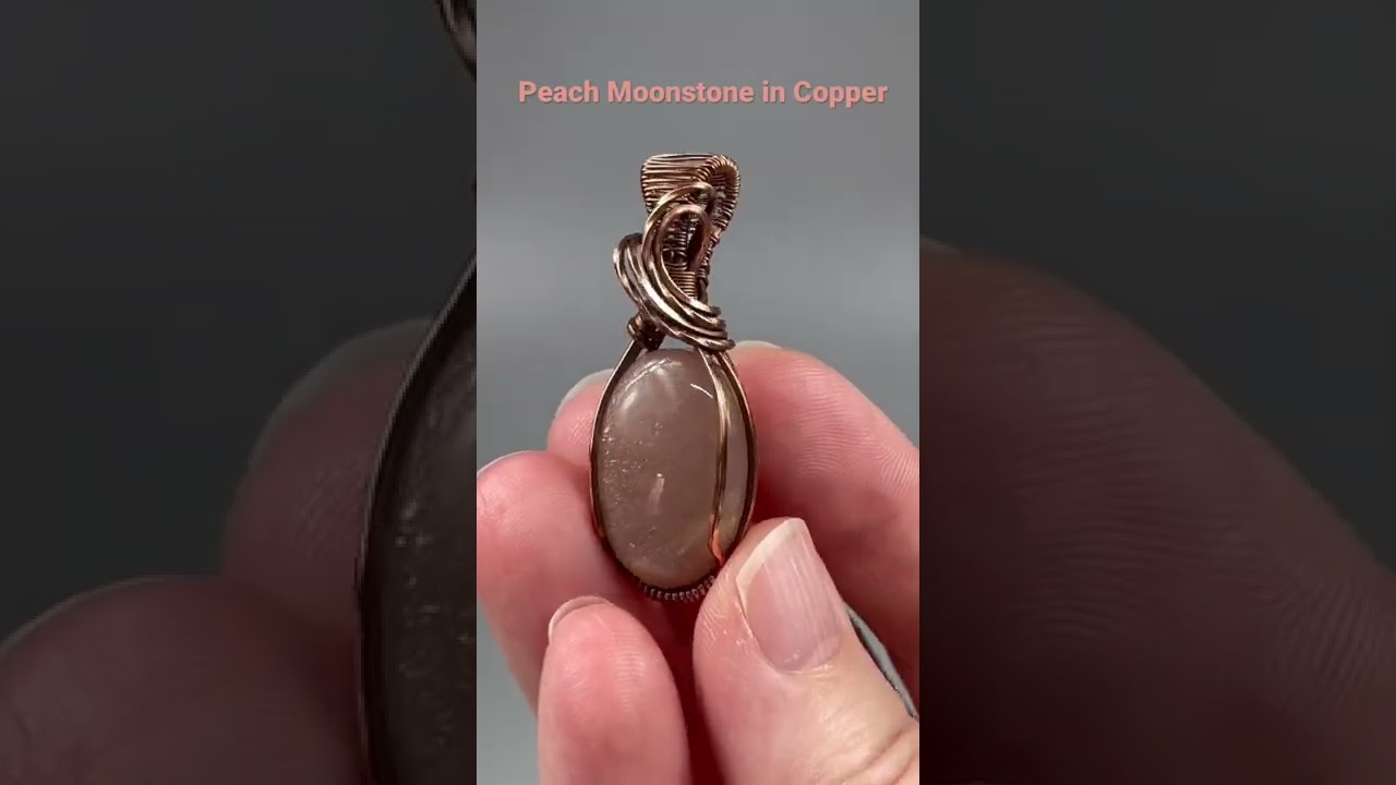 Peach moonstone cabochon wrapped in oxidized copper wire.
