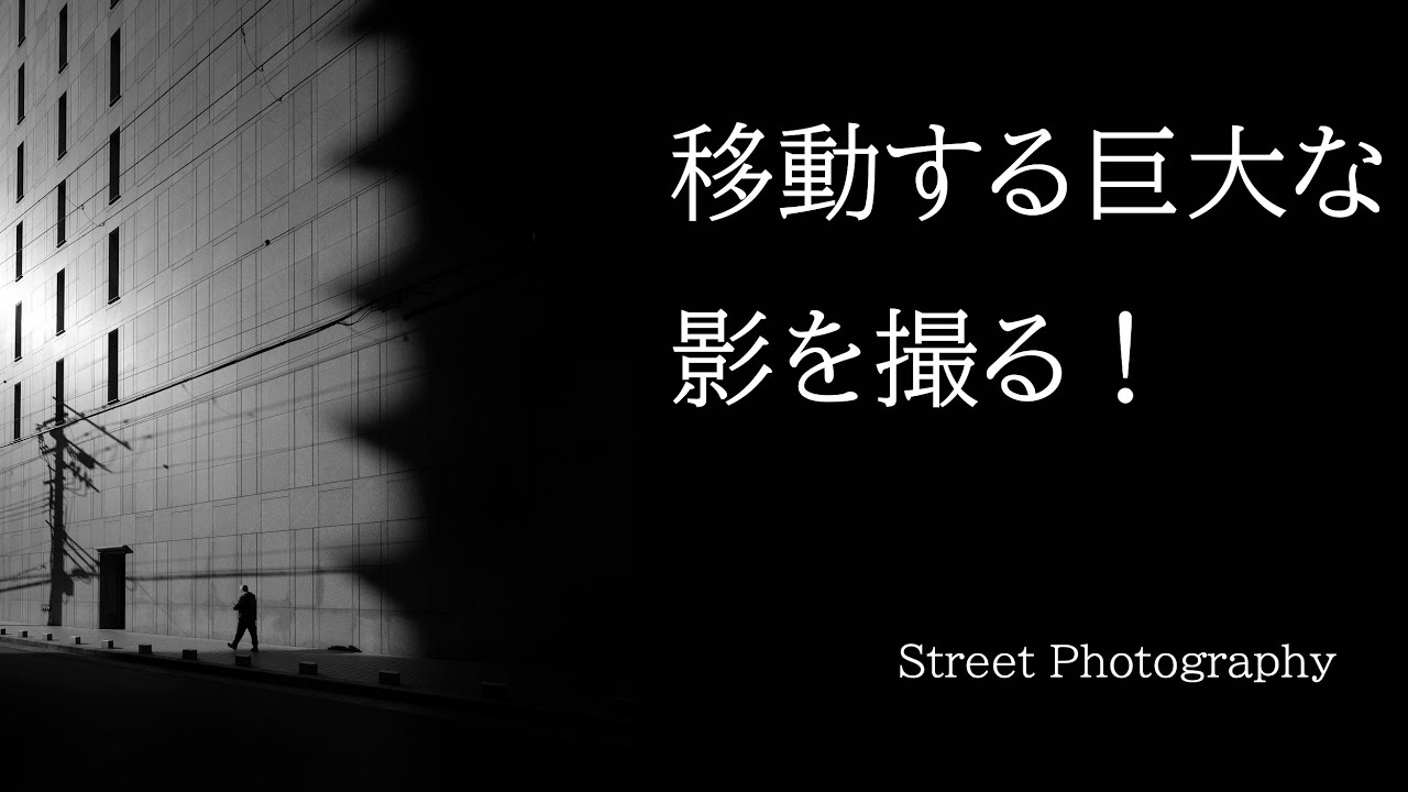 超広角レンズで都市のスケール感を出す。巨大な影と小さな人の対比。