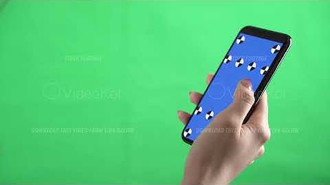 A person is holding a smartphone with tracking markers on it and swiping left on chroma key