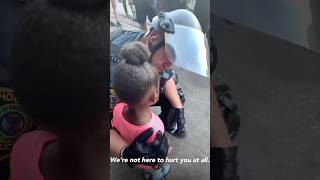Police officers comforts little girl after she asks : ’are you going to shoot us’