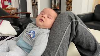 Dad puts baby to sleep by sliding hand on face while sitting up