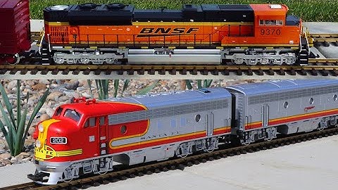 Huge model train set!   6 trains running on a big layout in my backyard in Spring