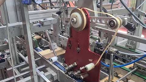 Fully automated double sided tape application on to cardboard packaging