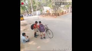 2 School Boys helping a differently abled person repair his tricycle