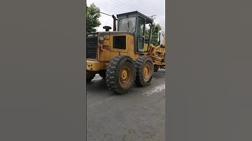 The motor grader is crossing the street at high speed
