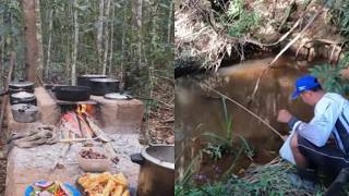 Pesca raiz num corrego selvagem no meio da mata com um frito no acampamento