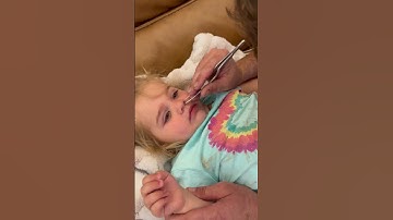 Dad has to use tweezers to remove a pony bead from his daughter