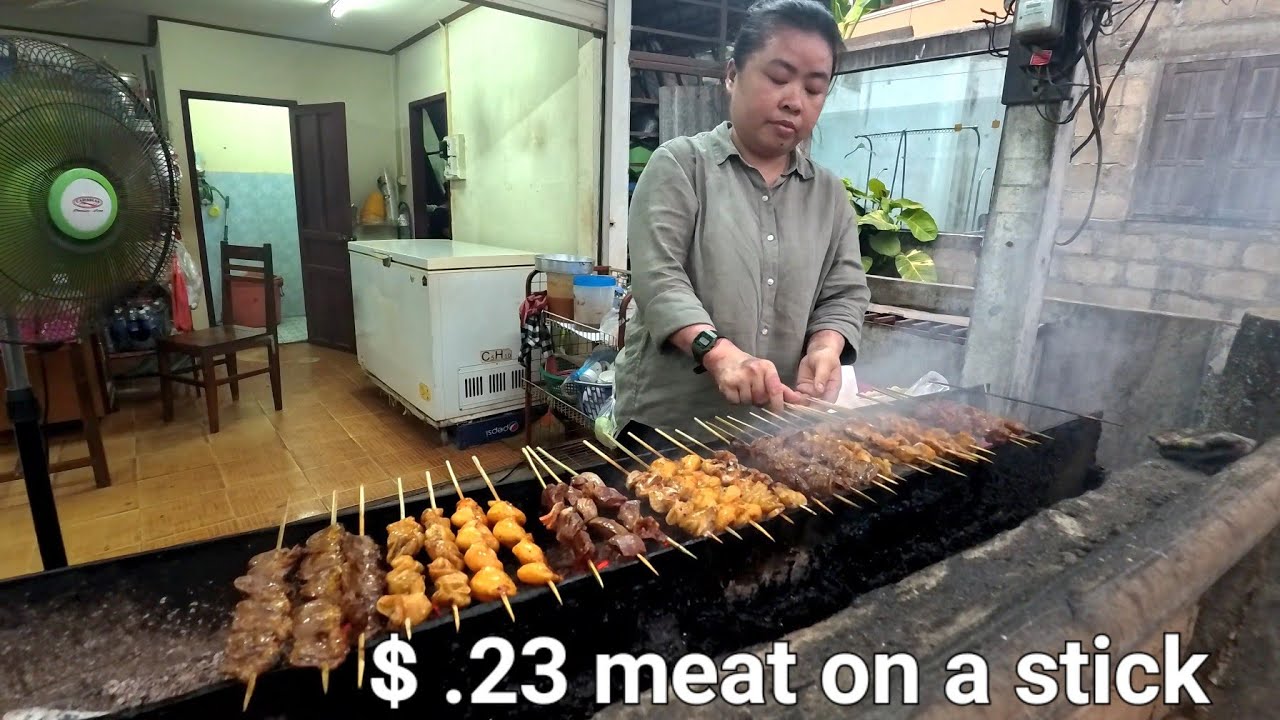 Buying meat on a stick at the neighborhood eating simple Lao food