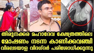 Fingerprint experts examining a temple hundi at Thirunakkara Mahadeva Temple following a burglary
