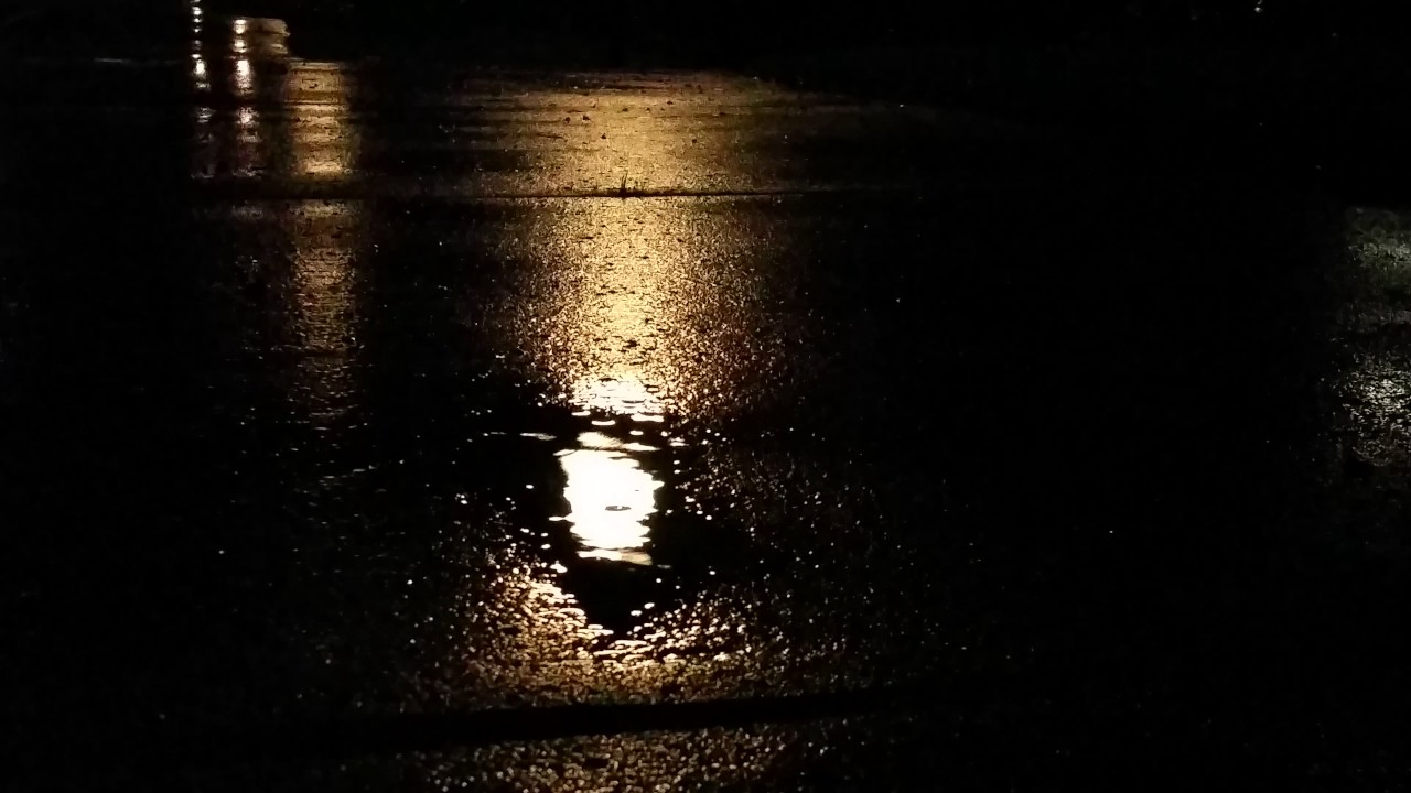 Raindrops on the sidewalk at night