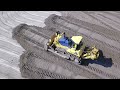 Komatsu D155A-5 pushing and spreading sand - Drone video