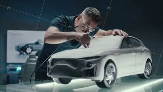 Senior Car Designer Works On Prototype Car Clay Sculpture Using A Rotating Tool