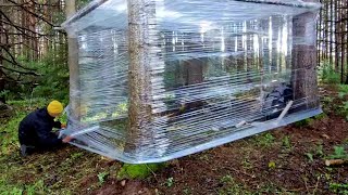 Building a cozy survival shelter in the wild forest using plastic wrap and a wood-burning stove.
