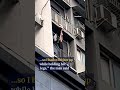 Heroic man holds up child dangling from balcony #shorts