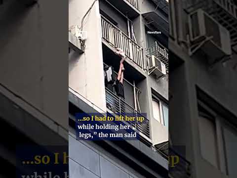 Heroic man holds up child dangling from balcony #shorts