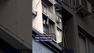 Heroic man holds up child dangling from balcony #shorts