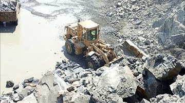 Heavy machine rocks loading in action: caterpillar wheel loader 966D rock loading trolleys#video#cat