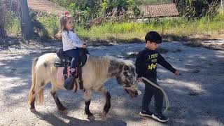Criança andando de cavalo ponei, Dudu e Mari