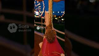 Two owls are enjoying a ride on a beautifully lit carousel at night. The scene feels magical