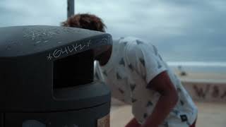 A Man Throwing Away Garbage That He Picked Up On The Beach