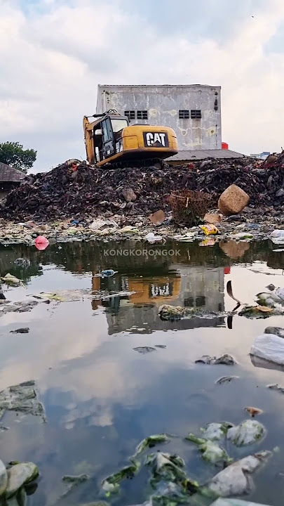 ALAT BERAT MENGEDUK SAMPAH YANG MENGGUNUNG