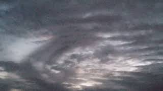 Swirled Looking Dark Clouds Slowly Drift Across The Evening Sky