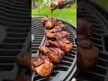 Crown Royal BBQ chicken drumsticks on a charcoal grill
