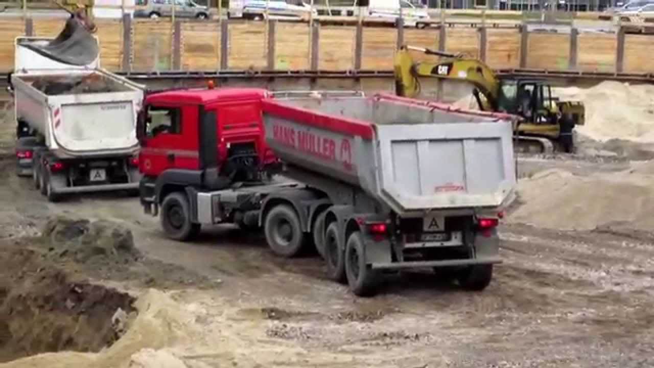 RUSH HOUR IN CONSTRUCTION SITE EXCAVATORS LOADING CONVOY OF DUMP TRUCKS