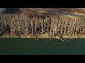 Drone flying over winter forest and big river wintertime  orange.