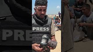 Gaza journalist holds the blood-soaked camera of a colleague killed in an Israeli strike