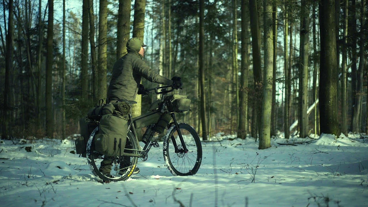 A solo overnight winter bikepacking trip in a snowy forest, bonefire, hammock and tarp.