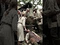 Fast shaky handheld shot.ActionVillagers gather around the dead blacksmith after a tree crushes him.