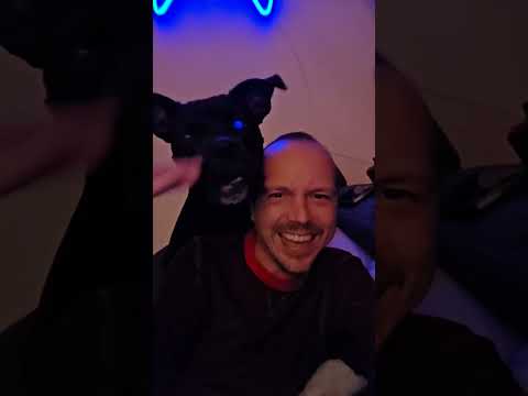 A man in his long johns goofing with his dog