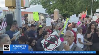Tempers flare as hundreds protest new asylum seeker facility in Queens