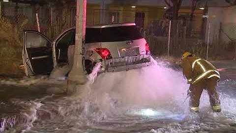 Car crashes and ends up on top of a fire hydrant in Los Angeles, California.