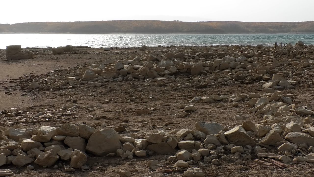 Bie niveli i ujit, dalin në sipërfaqe muret e shtëpive që dikur u përmbyten nga liqeni i Radoniqit