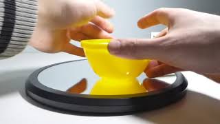 Large Yellow Plastic Lid With Lip Spins and Magically Wobbles Raising Center of Mass for 0:16