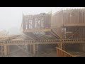 Watch as high winds and rain knock down several townhomes under construction in Dallas