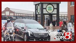 The hearse carrying Officer Brian Elliott leaves Beech Grove High School for Crown Hill Cemetery