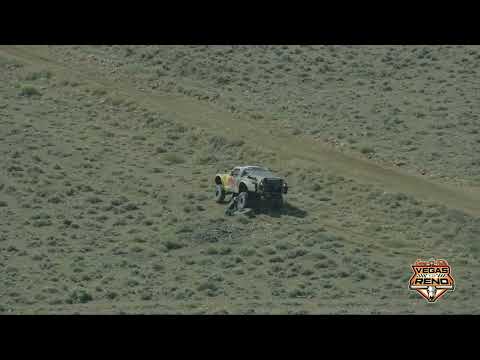 Bryce Menzies changing a flat as Robby Gordon goes by at the 2026 Vegas to Reno Off-Road Race