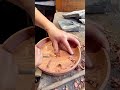 Hand-carving a wooden bowl surface into a smooth decorative shape