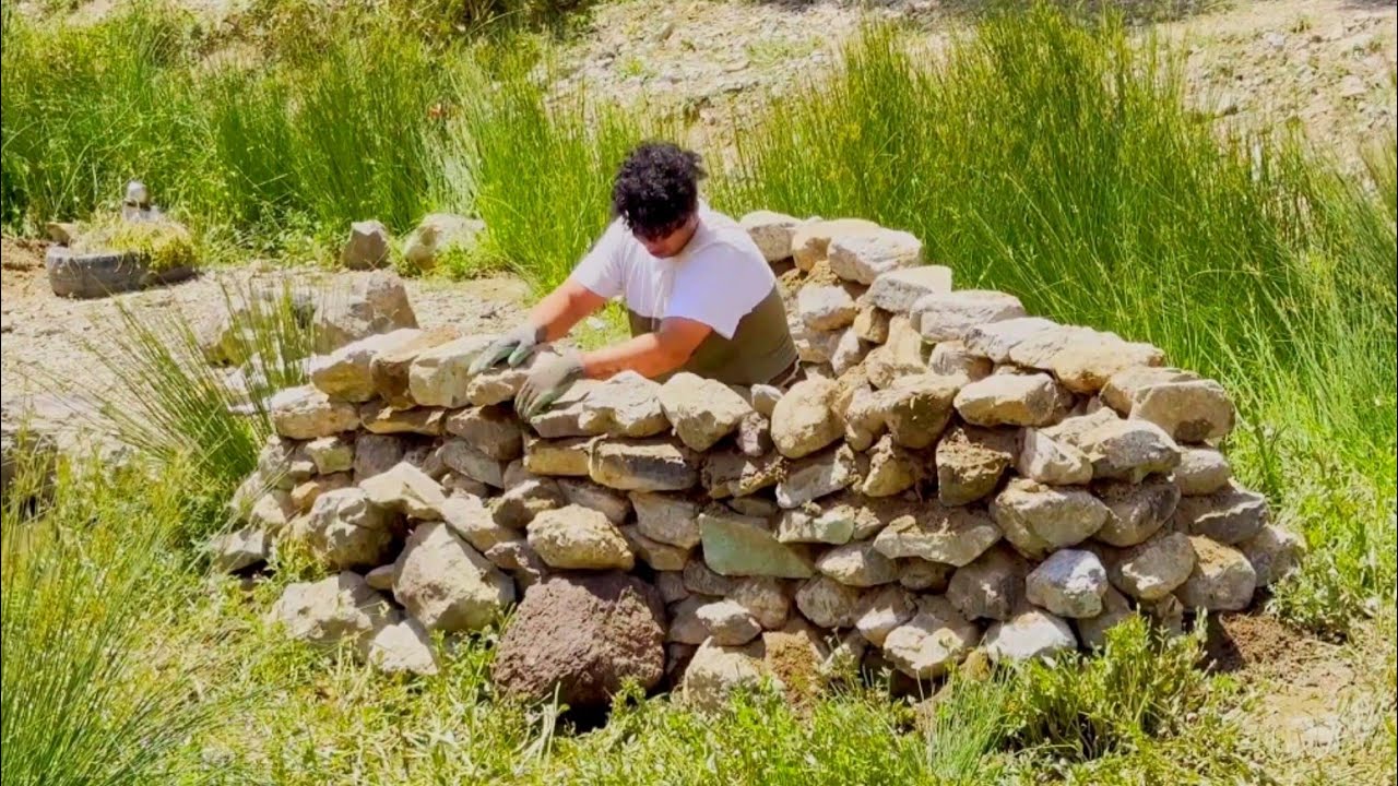 Building a warm and cozy stone shelter in the mountain. Survival skills