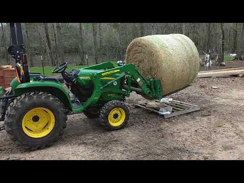 john-deere-3032e-handling-a-round-bale-of-hay